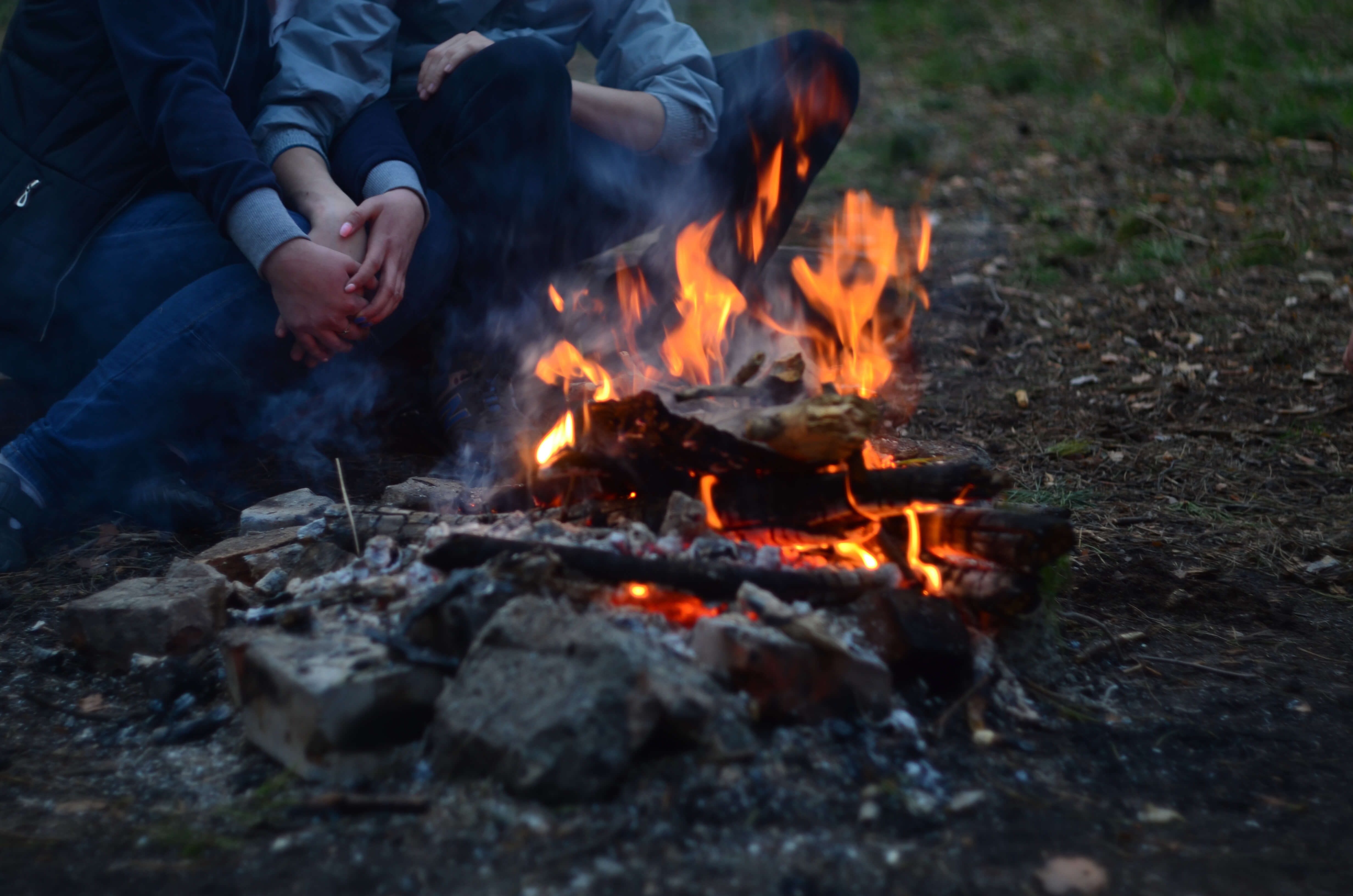 Foto Menschen sitzen gemütlich am Feuer - zum Foto