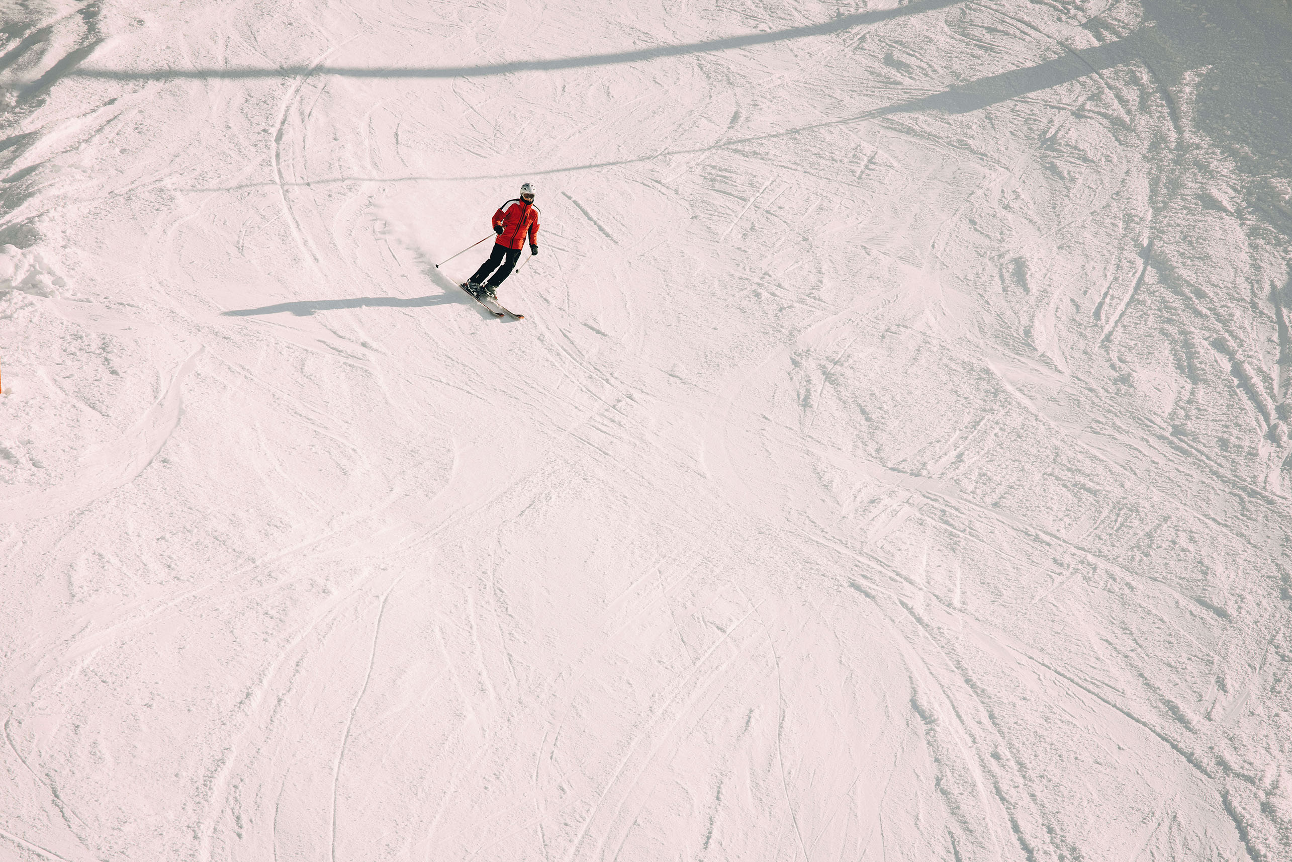 Foto einzelner Skifahrer auf Skipiste - zum Foto