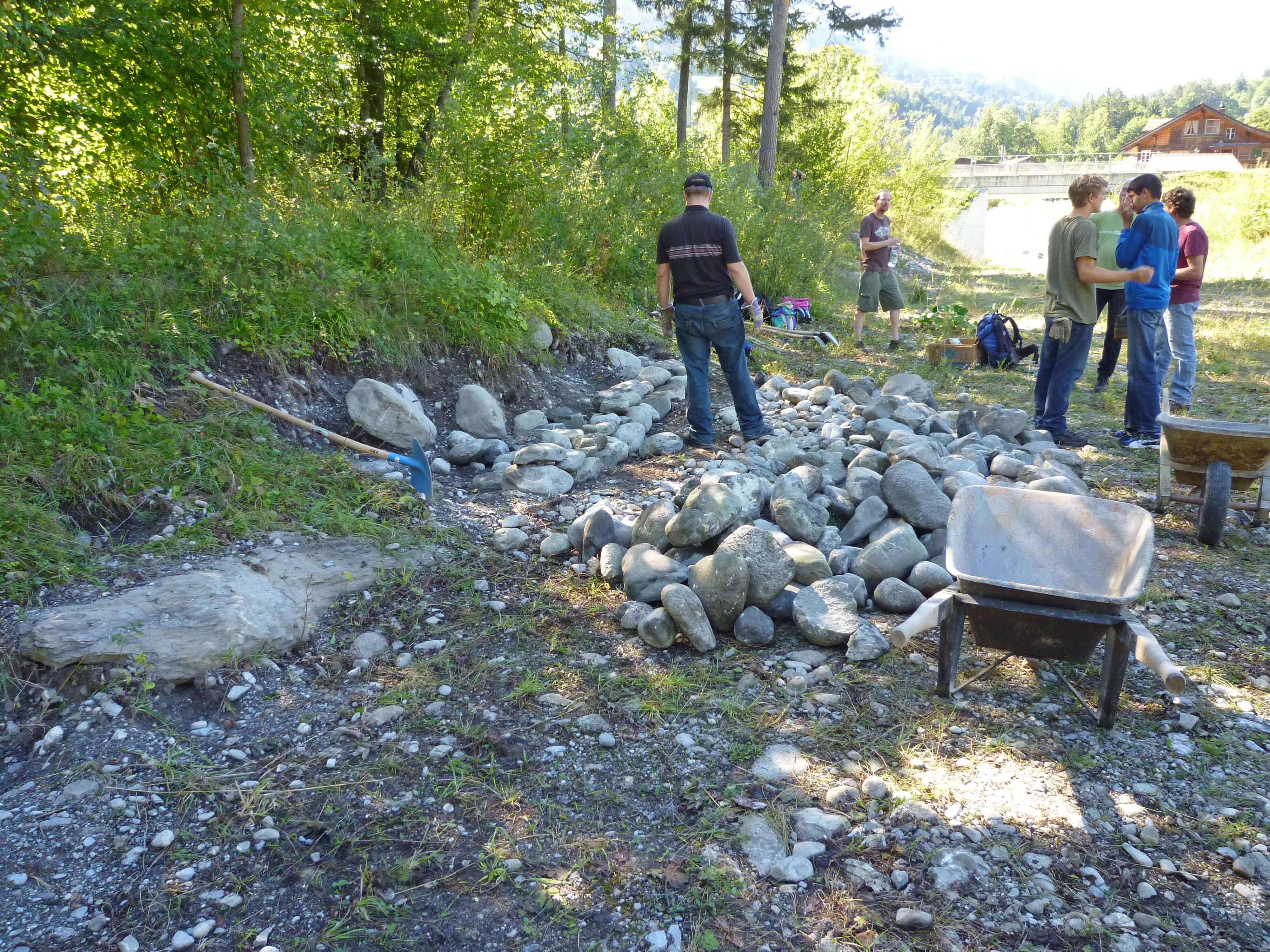 Foto Eine Gruppe von Freiwilligen schichtet Steine zu Steinlinsen - zum Foto