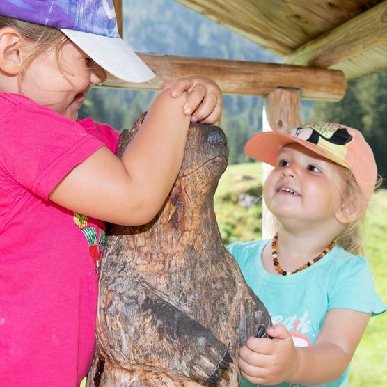 Foto Zwei Mädchen spielen mit einem hölzernen Murmeltier - zum Foto