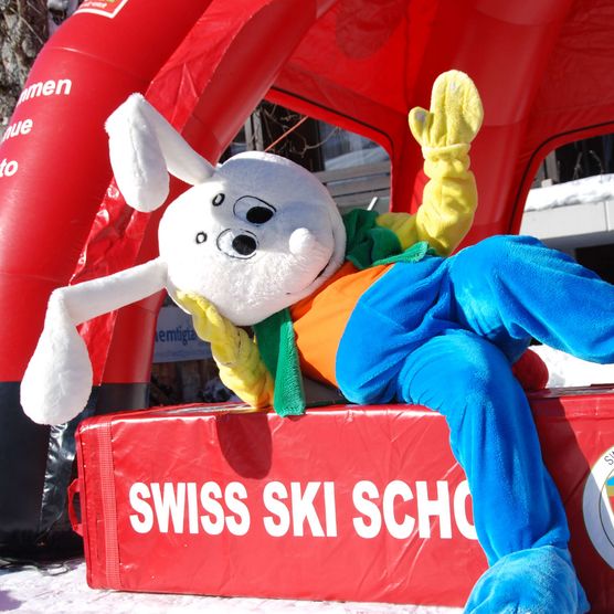 Photo The mascot Snowli sits on a Swiss Ski School element - to the photo