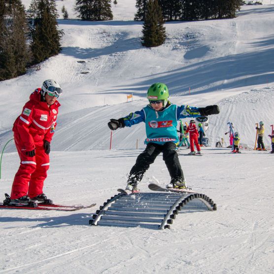Photo Children skiing over obstacle - to the photo